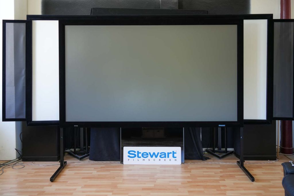 Stewart Filmscreen Phantom HALR+ als 16:9-Rahmenleinwand aufgebaut vor der matt weißen Leinwand des LowBeats Testkinos im Cinemascope (Foto: R. Vogt)